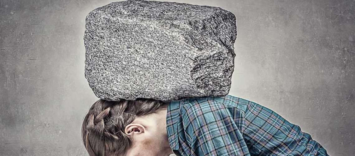 Student girl pressed with stone to opened book pages