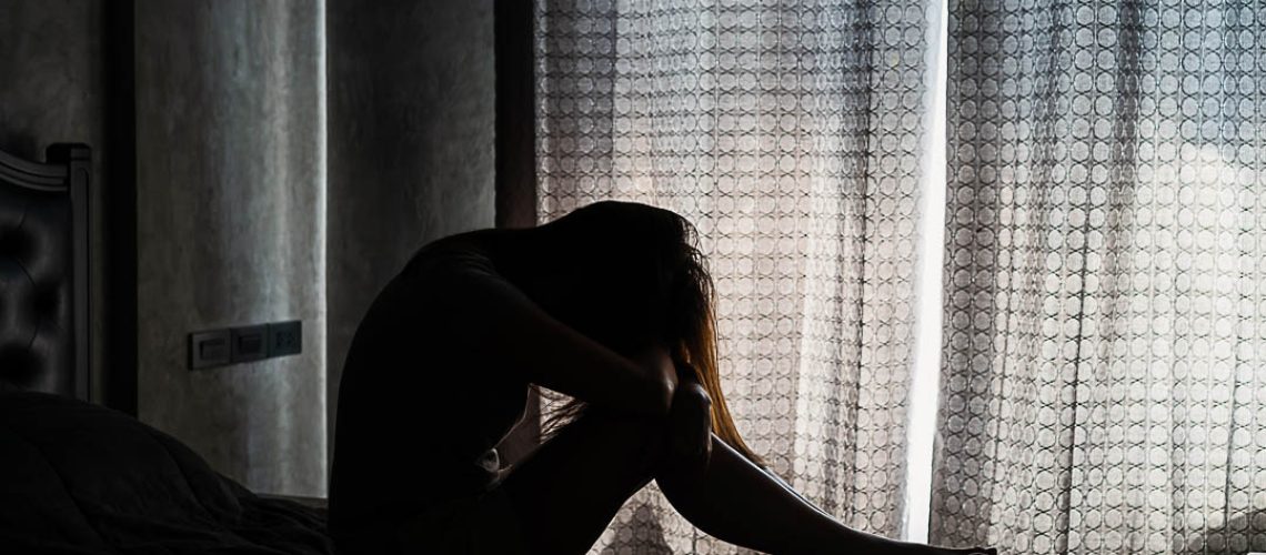 Lonely young woman depressed and stressed sitting in the dark bedroom, Negative emotion concept